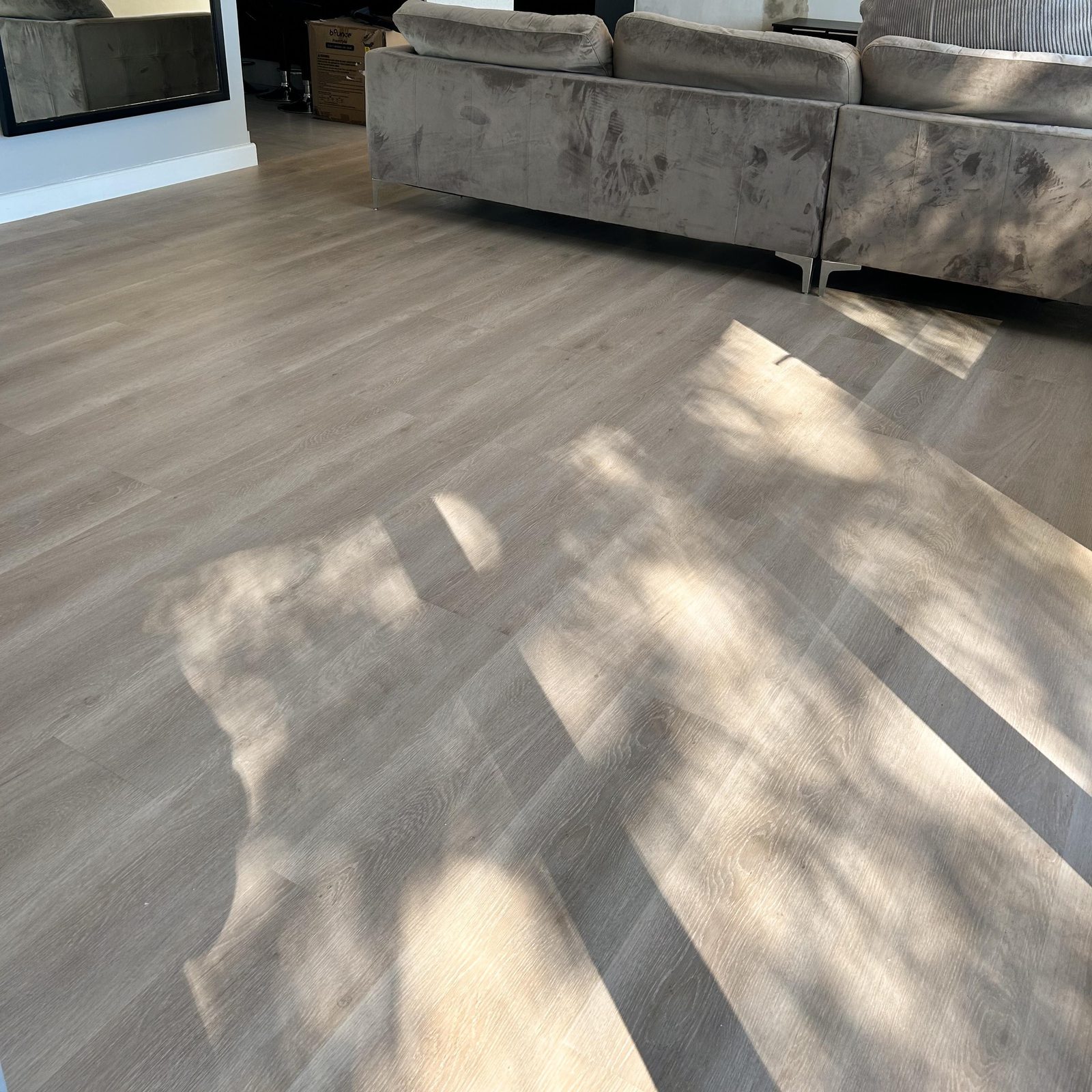 Warm-grey Aurora II luxury vinyl planks catching afternoon light