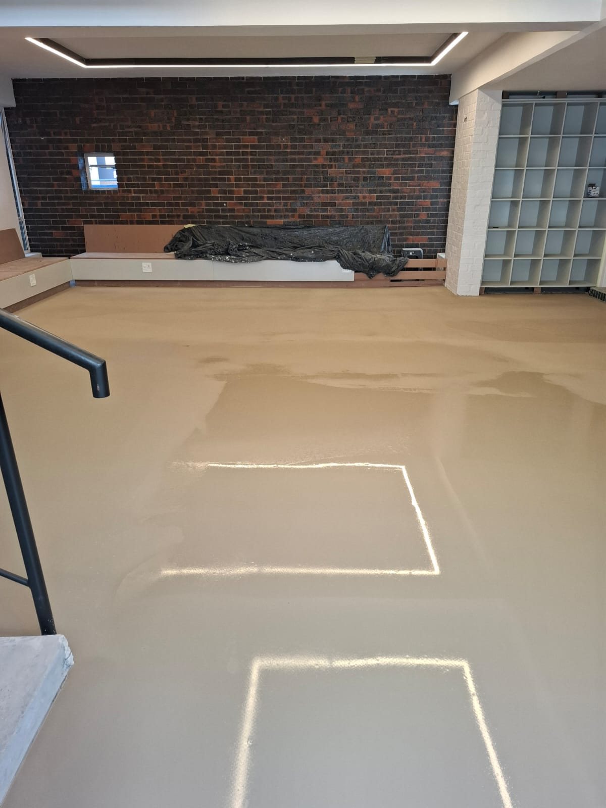 Self-levelling screed laid over the moisture barrier before the vinyl went down
