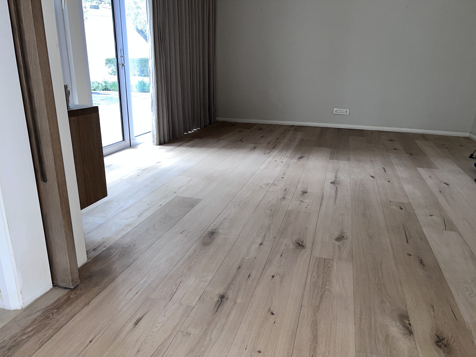 Natural raw-look oak flooring by the pool doors after WOCA Invisible sealing